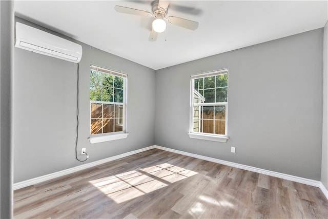 spare room with light wood-type flooring, a wealth of natural light, and a wall mounted AC