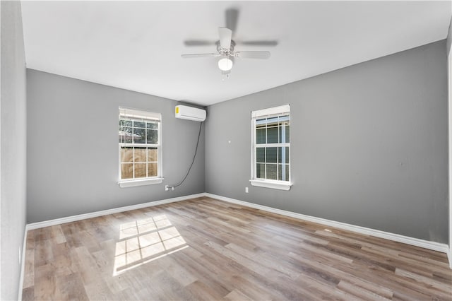 unfurnished room featuring ceiling fan, light hardwood / wood-style floors, and an AC wall unit