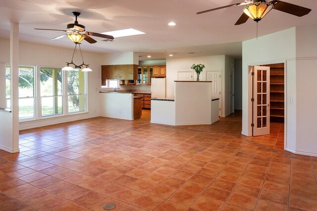 unfurnished living room featuring light tile patterned floors and ceiling fan