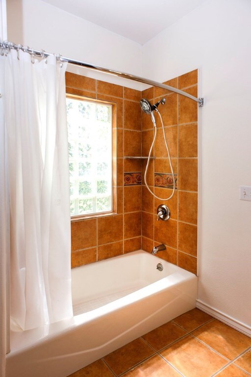 bathroom featuring tile patterned flooring and shower / tub combo