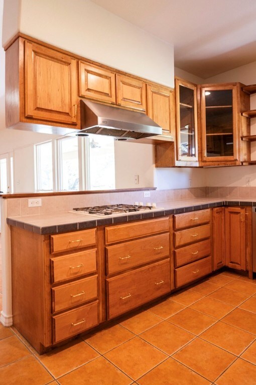 kitchen featuring tile counters, stainless steel gas cooktop, and light tile patterned flooring