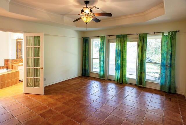 tiled spare room with a tray ceiling and a wealth of natural light