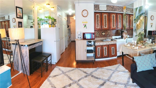 3938 Surfside Blvd Unit 1227, Corpus Christi, TX 78402 - kitchen with freestanding refrigerator, a sink, wood finished floors, backsplash, and crown molding