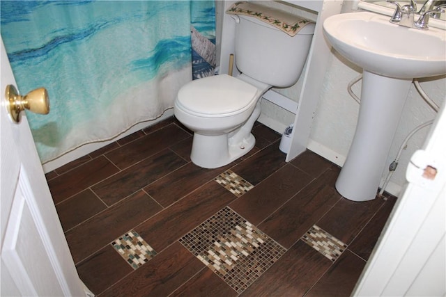 3938 Surfside Blvd Unit 1227, Corpus Christi, TX 78402 - bathroom featuring wood finished floors, toilet, a shower with shower curtain, and a sink