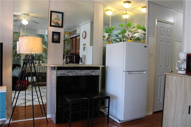 kitchen with dark wood-type flooring, ceiling fan, and white refrigerator