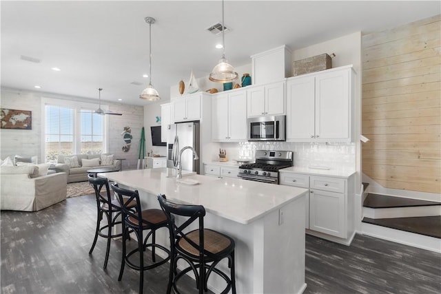 125 Fish Hook Ln, Port Aransas, TX 78373 - kitchen featuring dark wood-style floors, stainless steel appliances, visible vents, a sink, and a kitchen bar