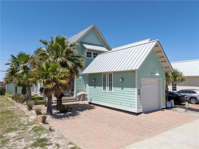 125 Fish Hook Ln, Port Aransas, TX 78373 - view of front facade with a garage, a standing seam roof, metal roof, and decorative driveway