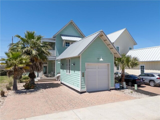 125 Fish Hook Ln, Port Aransas, TX 78373 - view of front of home featuring an attached garage, a standing seam roof, decorative driveway, and metal roof