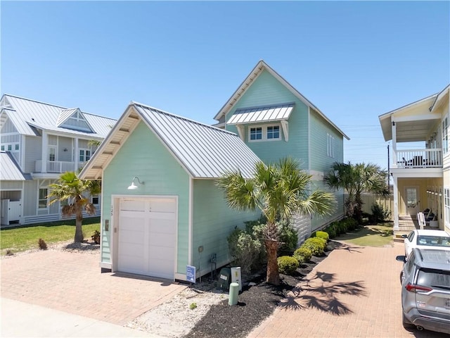 125 Fish Hook Ln, Port Aransas, TX 78373 - view of front of home with a detached garage, a standing seam roof, metal roof, and decorative driveway