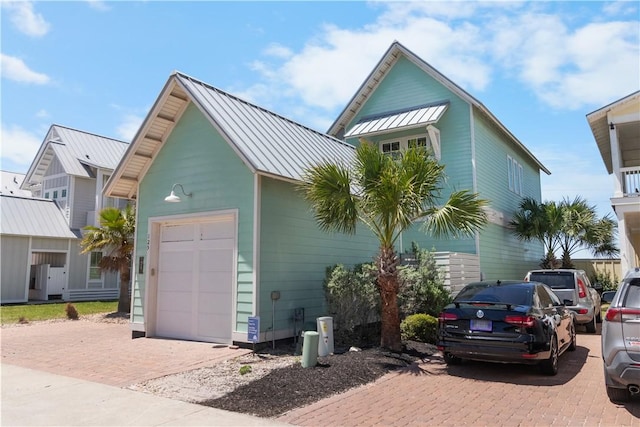 125 Fish Hook Ln, Port Aransas, TX 78373 - view of front of home featuring a garage, a standing seam roof, metal roof, and decorative driveway