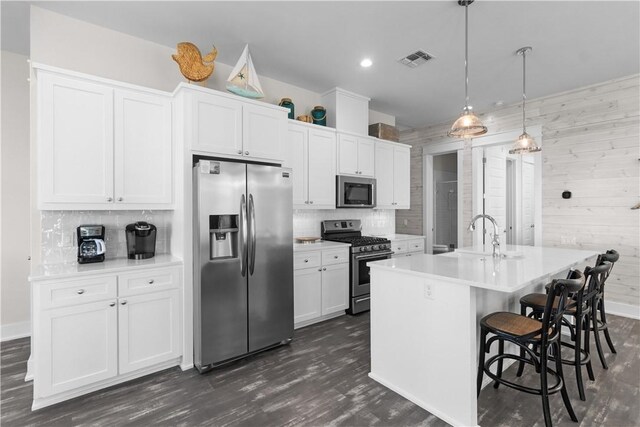 125 Fish Hook Ln, Port Aransas, TX 78373 - kitchen featuring stainless steel appliances, a sink, tasteful backsplash, visible vents, and dark wood-type flooring