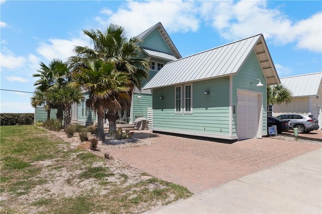 125 Fish Hook Ln, Port Aransas, TX 78373 - view of front of home with a garage, a standing seam roof, metal roof, and decorative driveway