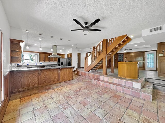 13622 Mountain Trl, Corpus Christi, TX 78410 - kitchen featuring stainless steel appliances, a ceiling fan, island range hood, a peninsula, and a textured ceiling