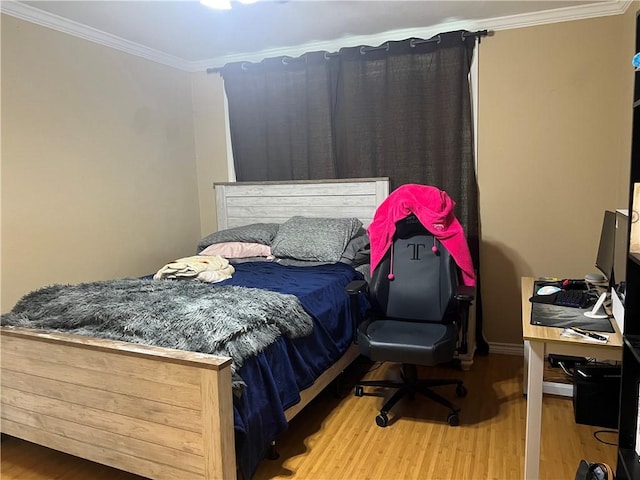 bedroom featuring crown molding and wood finished floors