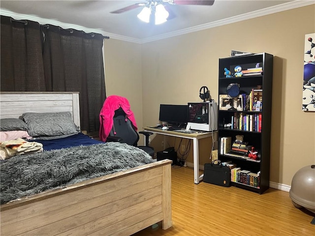 bedroom with baseboards, wood finished floors, ornamental molding, and a ceiling fan