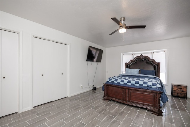 bedroom featuring light hardwood / wood-style flooring, ceiling fan, and multiple closets