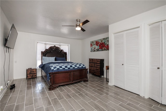 bedroom with hardwood / wood-style flooring, ceiling fan, and multiple closets