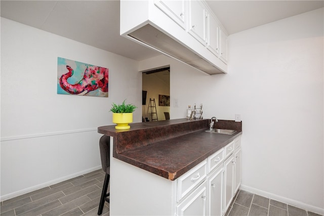 bar featuring white cabinetry, sink, and dark hardwood / wood-style flooring