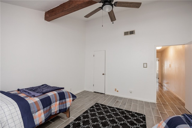 bedroom featuring a high ceiling, beam ceiling, ceiling fan, and hardwood / wood-style flooring