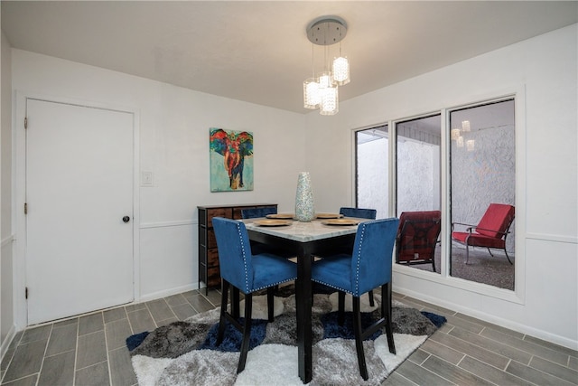 dining room with dark hardwood / wood-style flooring and an inviting chandelier