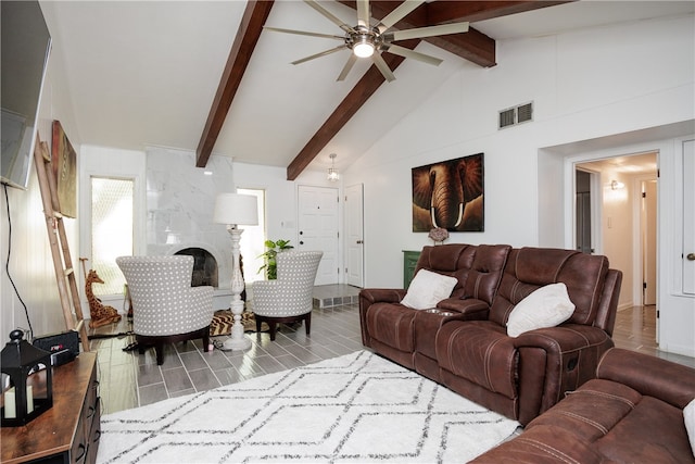 living room featuring a large fireplace, beamed ceiling, light hardwood / wood-style floors, and high vaulted ceiling