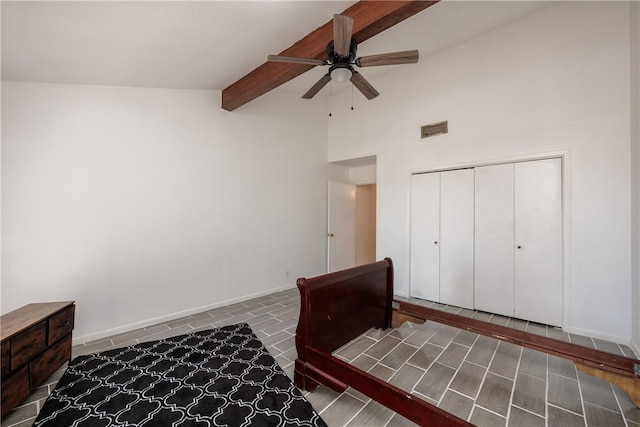 unfurnished bedroom featuring beamed ceiling, a closet, high vaulted ceiling, and ceiling fan