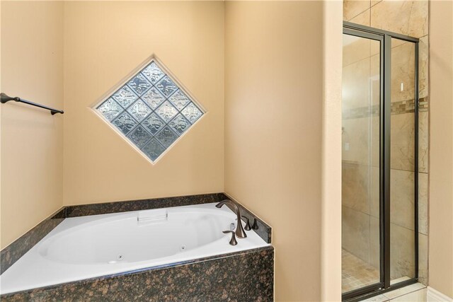 bathroom featuring a stall shower and a tub with jets