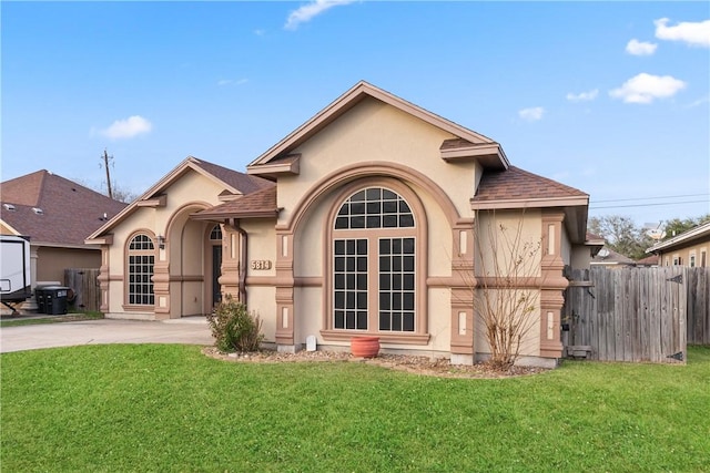 view of front of property with roof with shingles, stucco siding, fence, driveway, and a front lawn