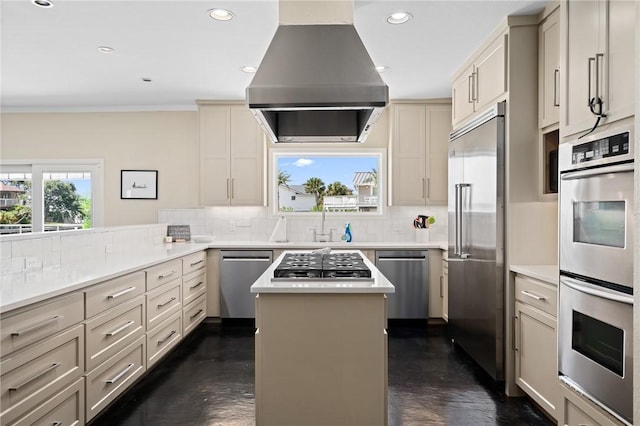 kitchen with appliances with stainless steel finishes, a center island, decorative backsplash, and island range hood