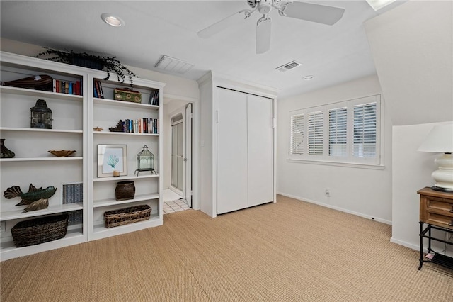 interior space featuring light colored carpet and ceiling fan