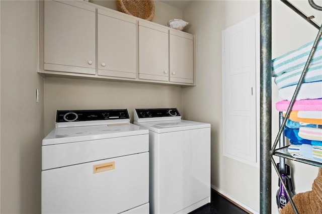 clothes washing area featuring cabinets and separate washer and dryer