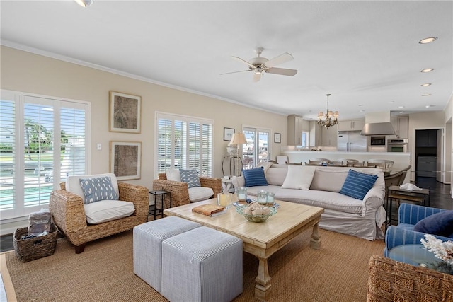 living room featuring ceiling fan with notable chandelier and ornamental molding