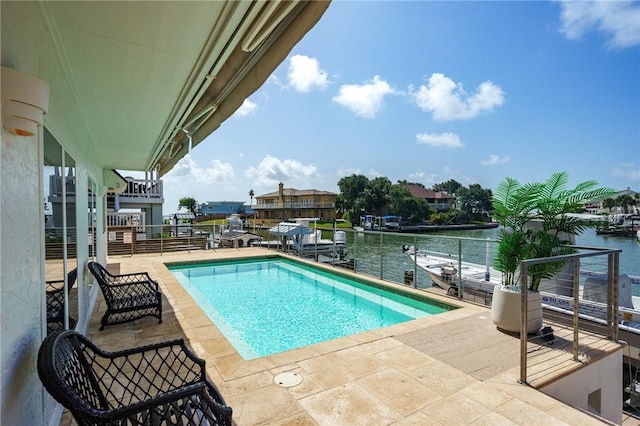 view of pool with a water view, a patio area, and a boat dock