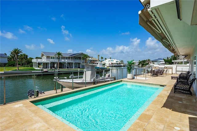 view of swimming pool with a water view and a patio