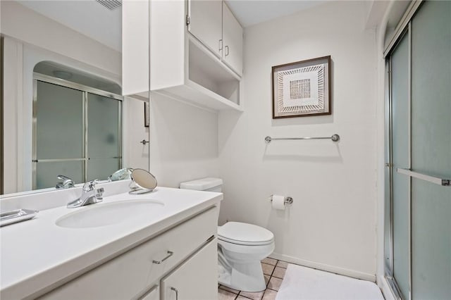 bathroom featuring tile patterned flooring, vanity, toilet, and walk in shower