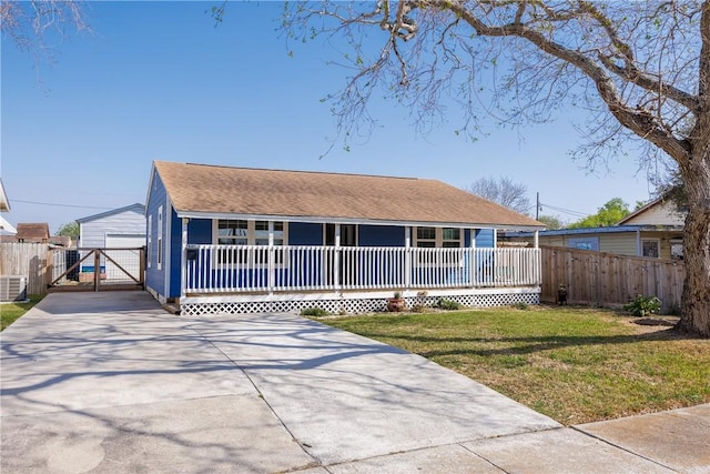 view of front facade featuring a front lawn, a gate, fence, and covered porch