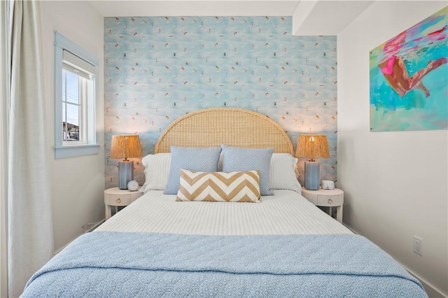 bedroom with an accent wall and wallpapered walls