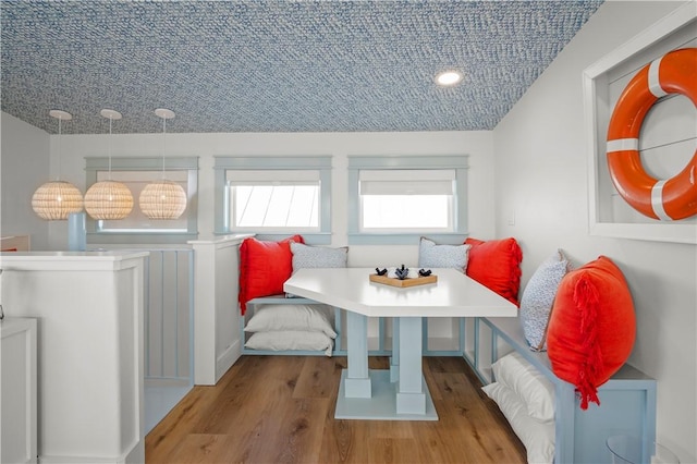 dining area with breakfast area and wood finished floors