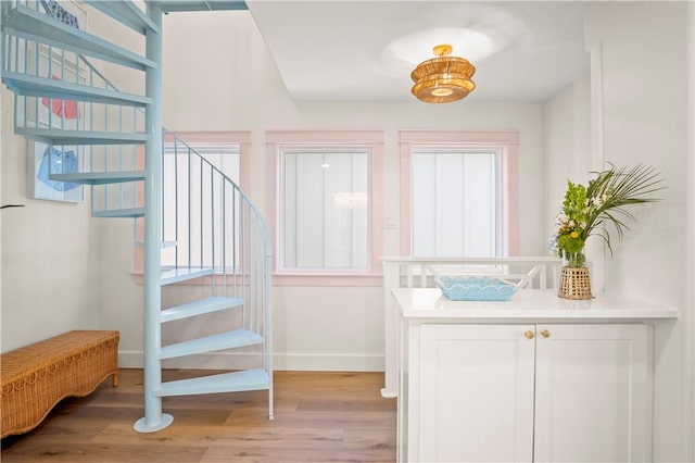 doorway to outside featuring light wood-type flooring, plenty of natural light, and stairway