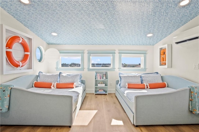bedroom with recessed lighting, a wall mounted AC, vaulted ceiling, wood finished floors, and baseboards