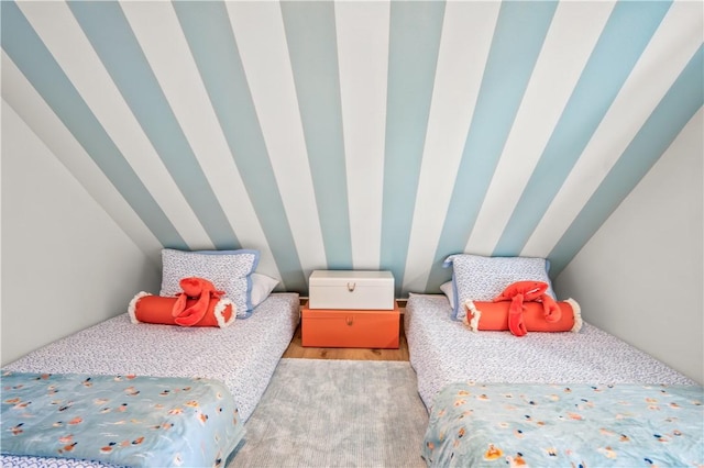bedroom with lofted ceiling and wood finished floors
