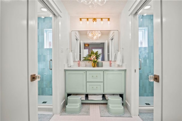 full bathroom featuring a stall shower, a chandelier, and vanity