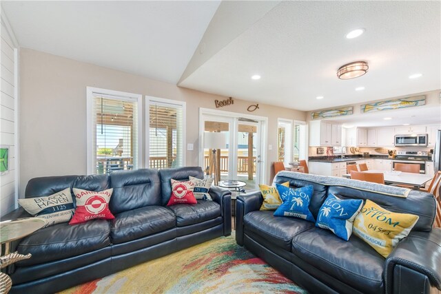 living room featuring sink and vaulted ceiling