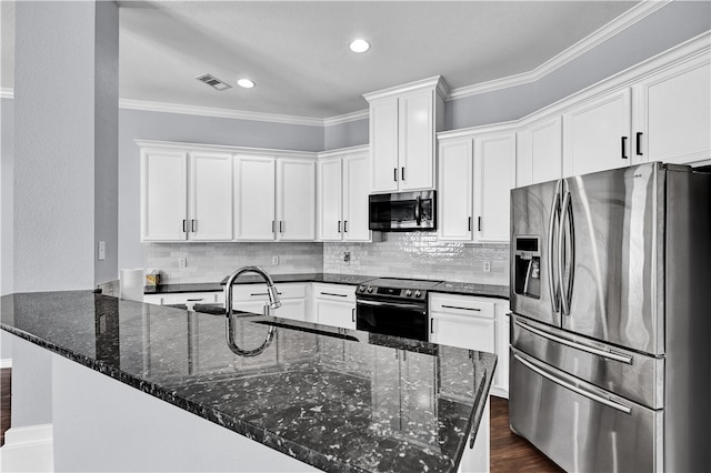 kitchen with white cabinetry, stainless steel appliances, dark stone counters, and crown molding