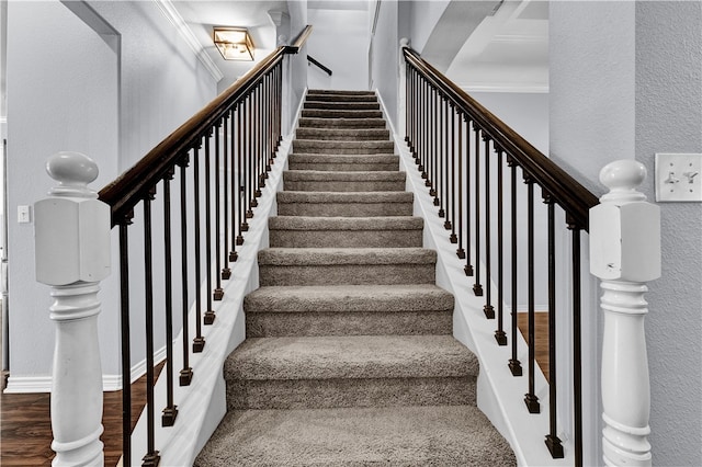 staircase featuring hardwood / wood-style flooring and crown molding