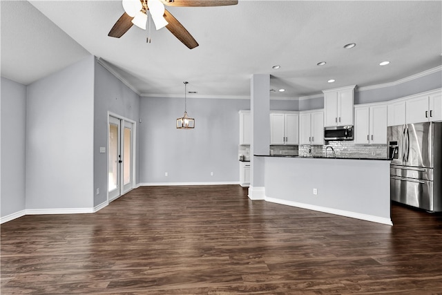 kitchen with crown molding, stainless steel appliances, white cabinetry, decorative light fixtures, and dark hardwood / wood-style flooring