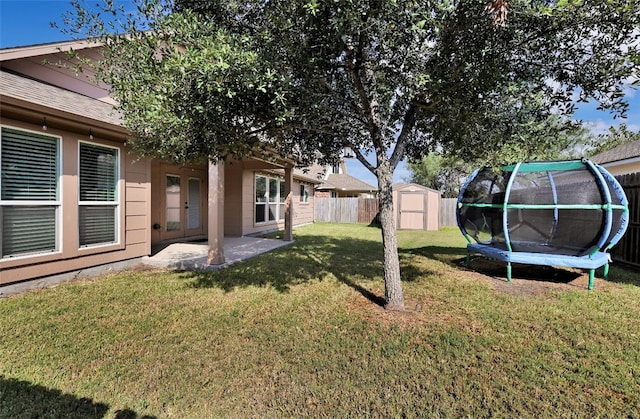 view of yard with a shed, a trampoline, and a patio