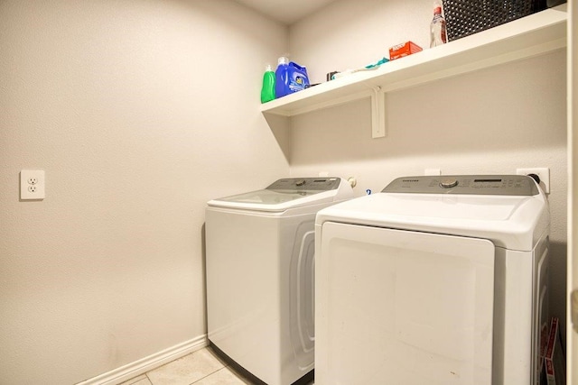 laundry room with light tile patterned floors, independent washer and dryer, laundry area, and baseboards