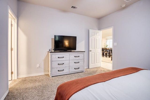 bedroom featuring visible vents, light carpet, and baseboards