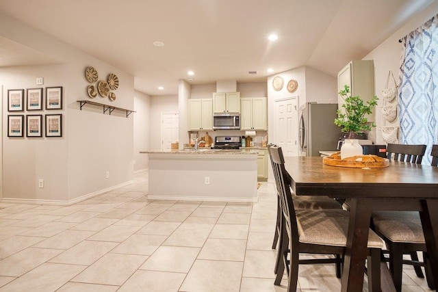 kitchen with light tile patterned floors, a kitchen island with sink, recessed lighting, and appliances with stainless steel finishes